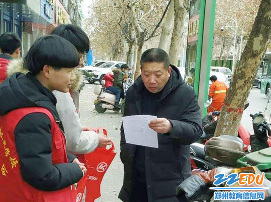 学生志愿者走上街头发放倡议书 学生志愿者走上街头发放倡议书